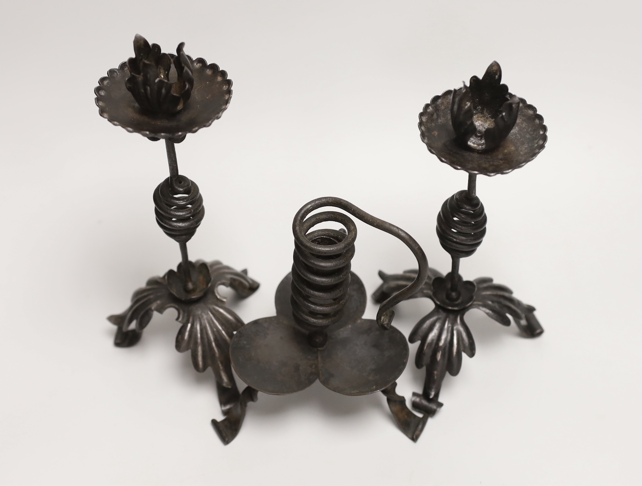 A pair of Arts & Crafts wrought iron candlesticks and a similar chamberstick, 1880s, made by Suffolk Whitesmith, member of Setchell family, tallest 24cm. Provenance: by family descent.
